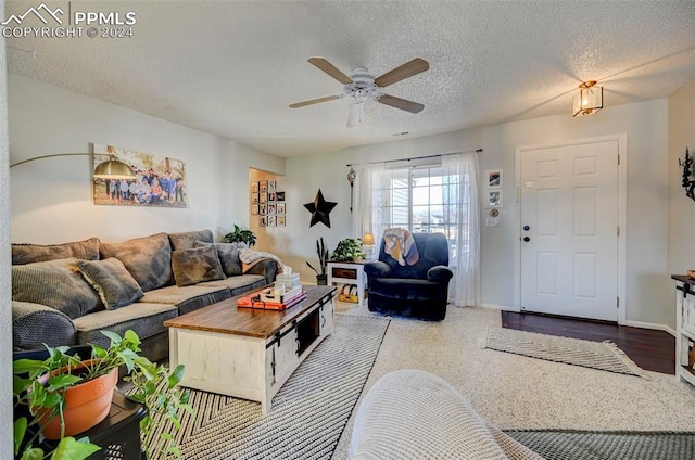 living room with ceiling fan and a textured ceiling