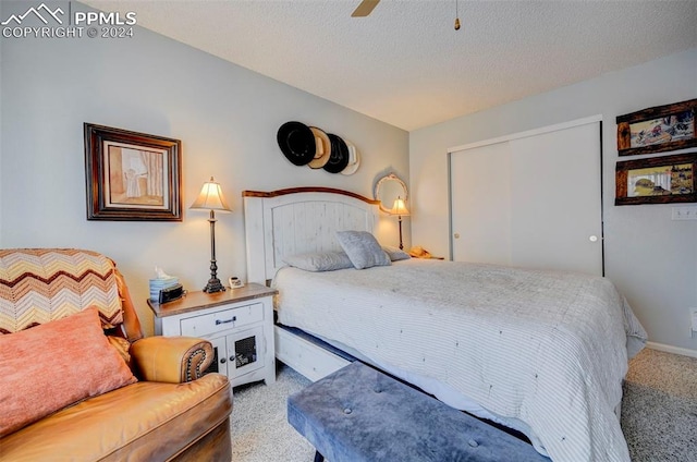 carpeted bedroom featuring a textured ceiling, a closet, and ceiling fan