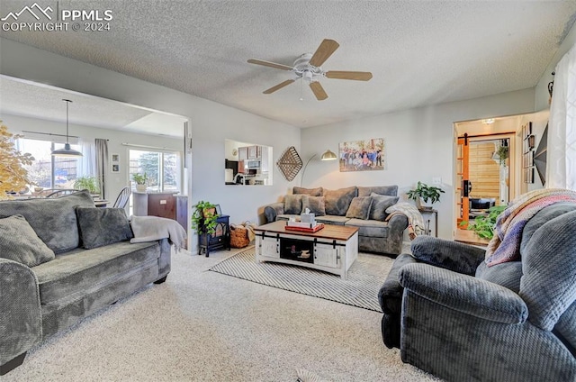 living room with ceiling fan and a textured ceiling