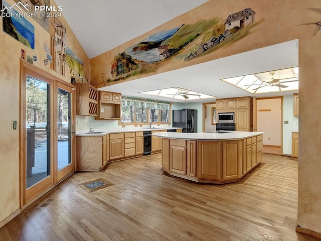 kitchen with ceiling fan, beverage cooler, black appliances, a center island, and light hardwood / wood-style floors