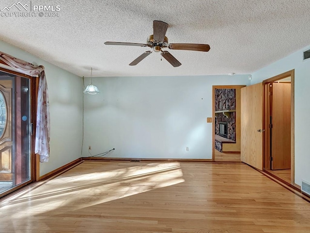 unfurnished room featuring ceiling fan, light hardwood / wood-style flooring, and a textured ceiling