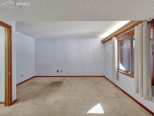 carpeted empty room featuring a textured ceiling