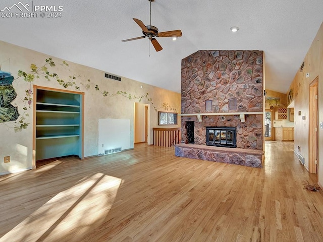 unfurnished living room featuring ceiling fan, a fireplace, high vaulted ceiling, and wood-type flooring