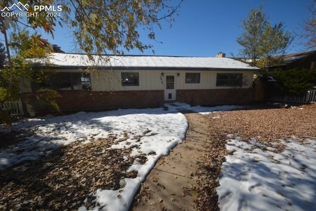 view of snow covered back of property