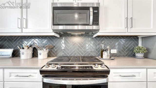 kitchen with backsplash, white cabinetry, and appliances with stainless steel finishes