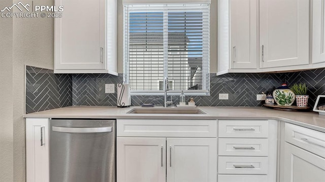 kitchen with backsplash, white cabinetry, sink, and stainless steel dishwasher