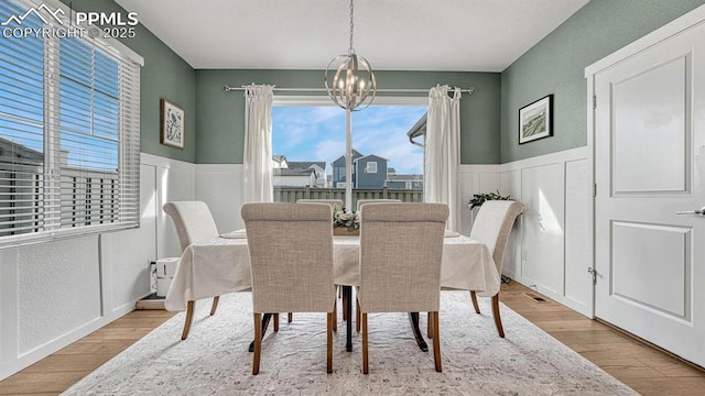 dining room featuring light wood-type flooring and an inviting chandelier