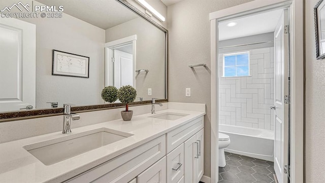 full bathroom with tile patterned flooring, vanity, tiled shower / bath combo, and toilet