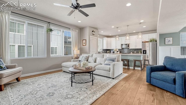 living room featuring ceiling fan and light hardwood / wood-style flooring