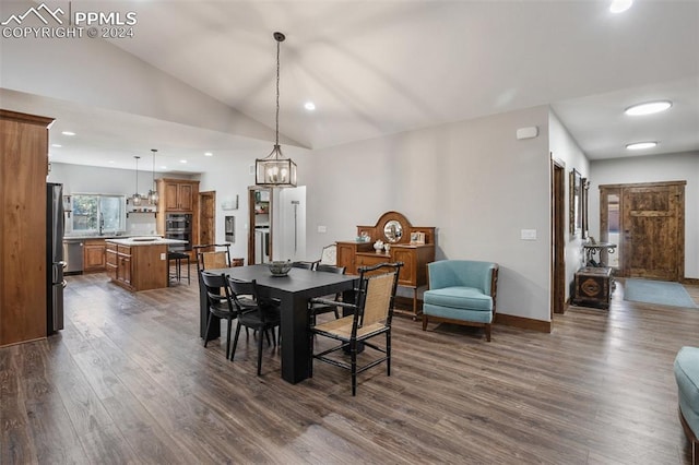 dining area featuring sink, dark wood-type flooring, and vaulted ceiling