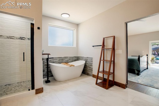 bathroom featuring plenty of natural light, tile walls, and plus walk in shower