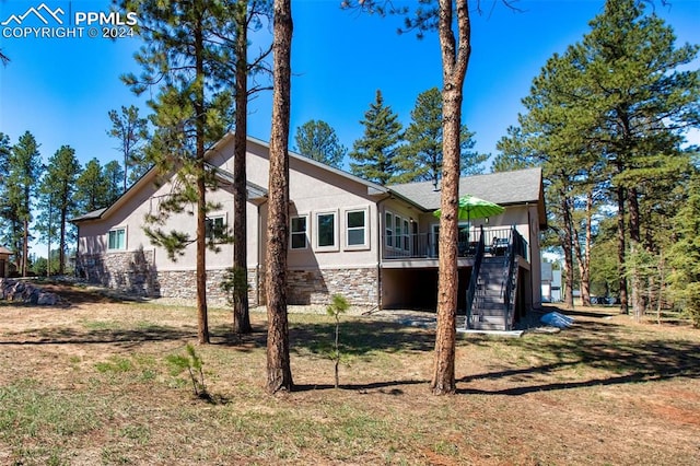 view of side of property featuring a deck and a lawn