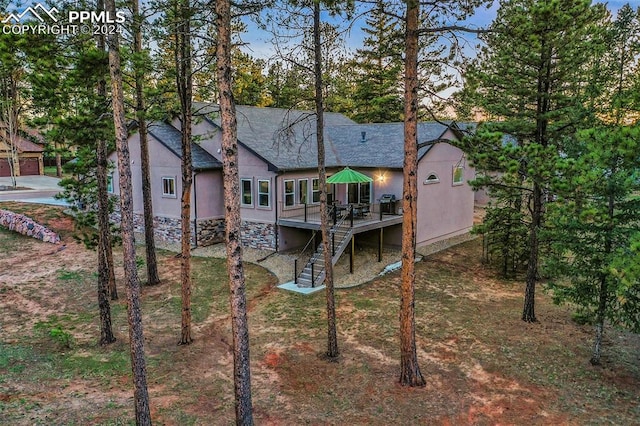 rear view of property featuring a wooden deck