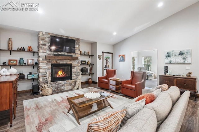 living room with a fireplace, vaulted ceiling, and light wood-type flooring