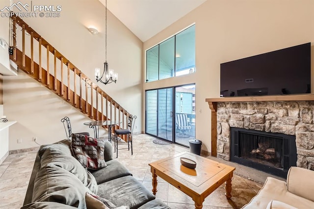 living room featuring a fireplace, high vaulted ceiling, and an inviting chandelier