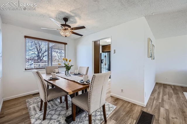 dining room with ceiling fan, a textured ceiling, and light wood-type flooring