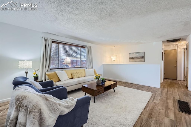 living room featuring wood-type flooring and a textured ceiling