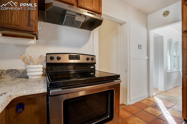 kitchen with light stone countertops and stainless steel range with electric cooktop