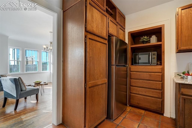 kitchen with stainless steel fridge and a chandelier