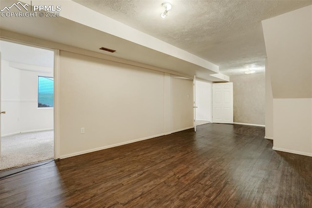 basement with dark hardwood / wood-style floors and a textured ceiling