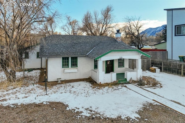 snow covered house featuring a mountain view