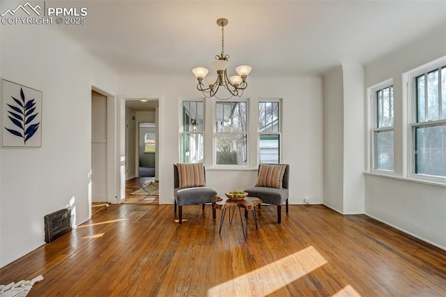 sitting room featuring hardwood / wood-style floors and a notable chandelier