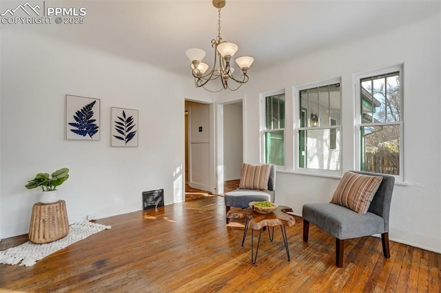 sitting room with hardwood / wood-style flooring and a notable chandelier