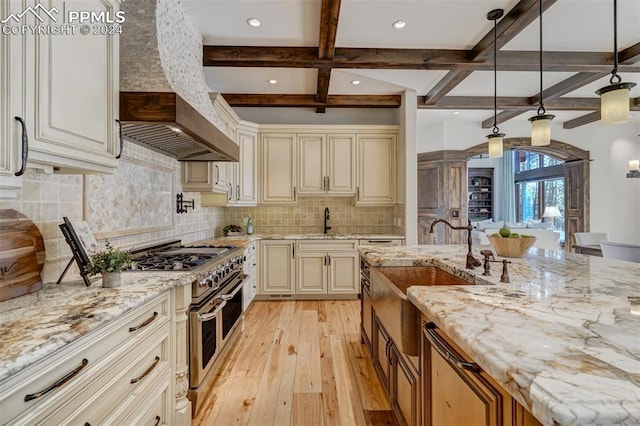 kitchen with wall chimney exhaust hood, light stone counters, backsplash, double oven range, and pendant lighting