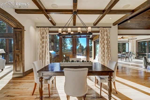 dining space with coffered ceiling, beamed ceiling, light hardwood / wood-style floors, and ceiling fan with notable chandelier