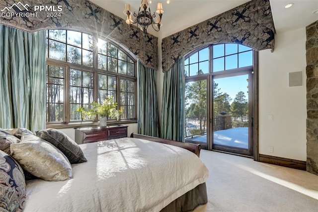 carpeted bedroom with a chandelier, access to outside, and multiple windows