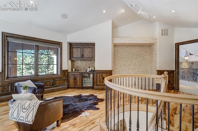 interior space featuring a crib, light hardwood / wood-style floors, and lofted ceiling