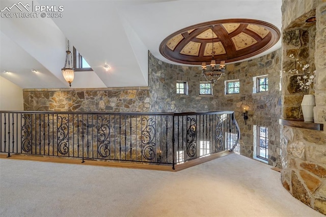 hallway featuring carpet flooring and a notable chandelier