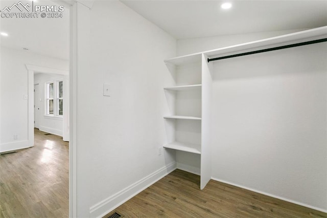 walk in closet with dark hardwood / wood-style floors and lofted ceiling