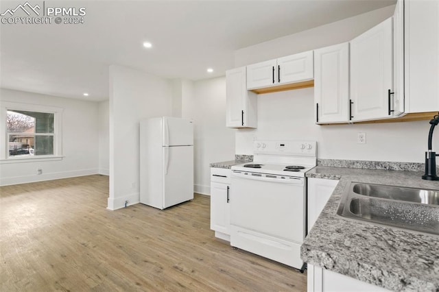 kitchen with white cabinets, light hardwood / wood-style floors, white appliances, and sink