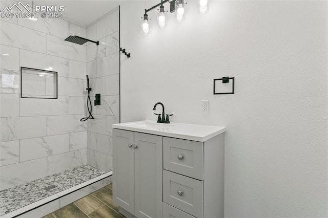 bathroom featuring a tile shower and vanity