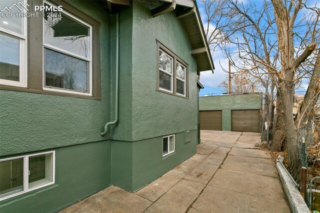 view of side of home with an outdoor structure and a garage