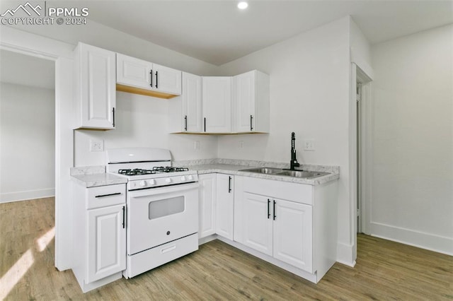 kitchen featuring light hardwood / wood-style floors, white cabinetry, sink, and gas range gas stove