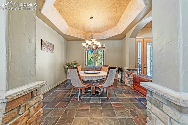 dining area featuring a chandelier and a tray ceiling