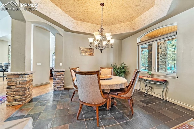 dining area with a raised ceiling and an inviting chandelier