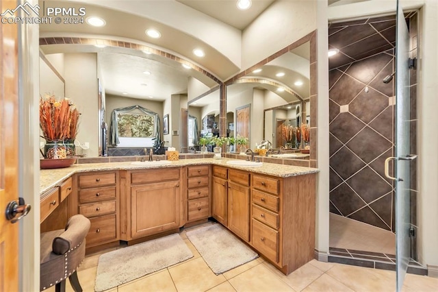 bathroom with tile patterned floors, vanity, and a tile shower