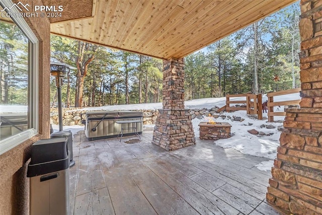 snow covered patio with a hot tub