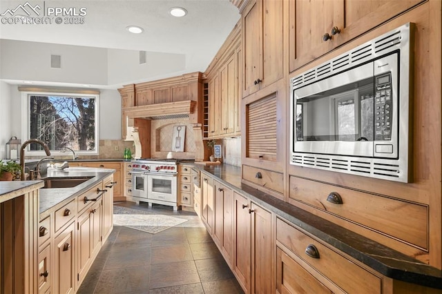 kitchen with decorative backsplash, sink, stainless steel appliances, and light brown cabinetry