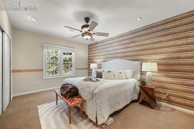 carpeted bedroom featuring a closet, rustic walls, and ceiling fan