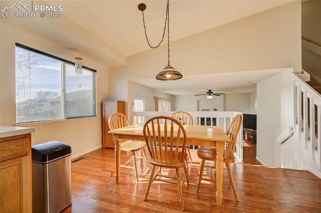 dining space featuring ceiling fan, light hardwood / wood-style floors, and lofted ceiling