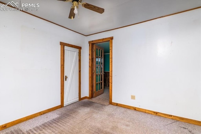 carpeted spare room featuring ceiling fan and crown molding