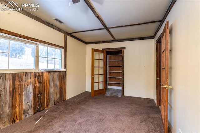 carpeted spare room featuring ceiling fan and french doors