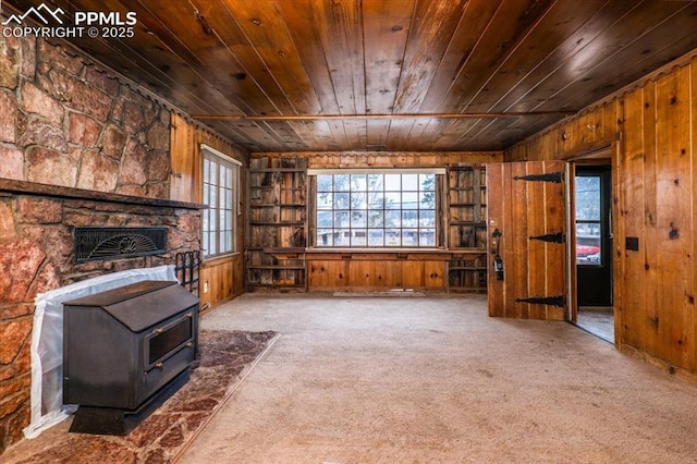 unfurnished living room with wood walls and carpet floors