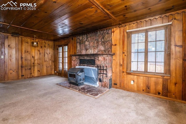 unfurnished living room featuring carpet floors, wood ceiling, and wood walls