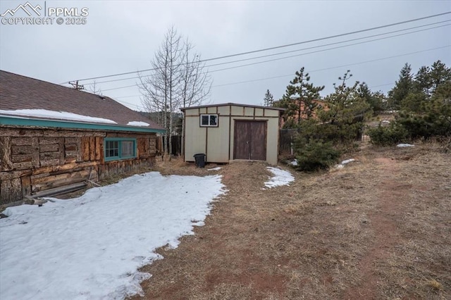 yard covered in snow featuring a shed