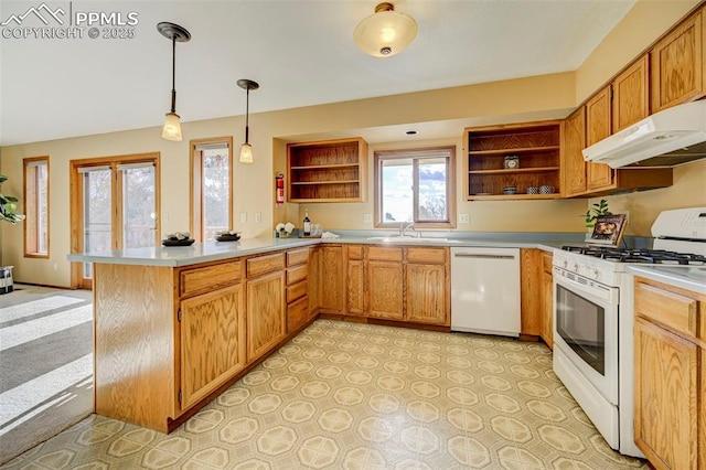 kitchen featuring kitchen peninsula, white appliances, sink, decorative light fixtures, and range hood